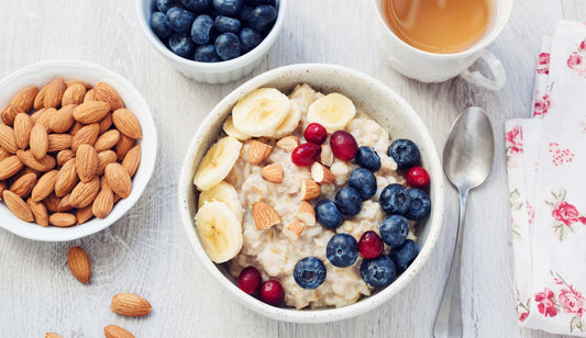 A top down shot of porridge with banana, blueberries and almonds.