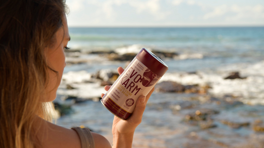Girl looking at a tin of Evo Kalm at the ocean