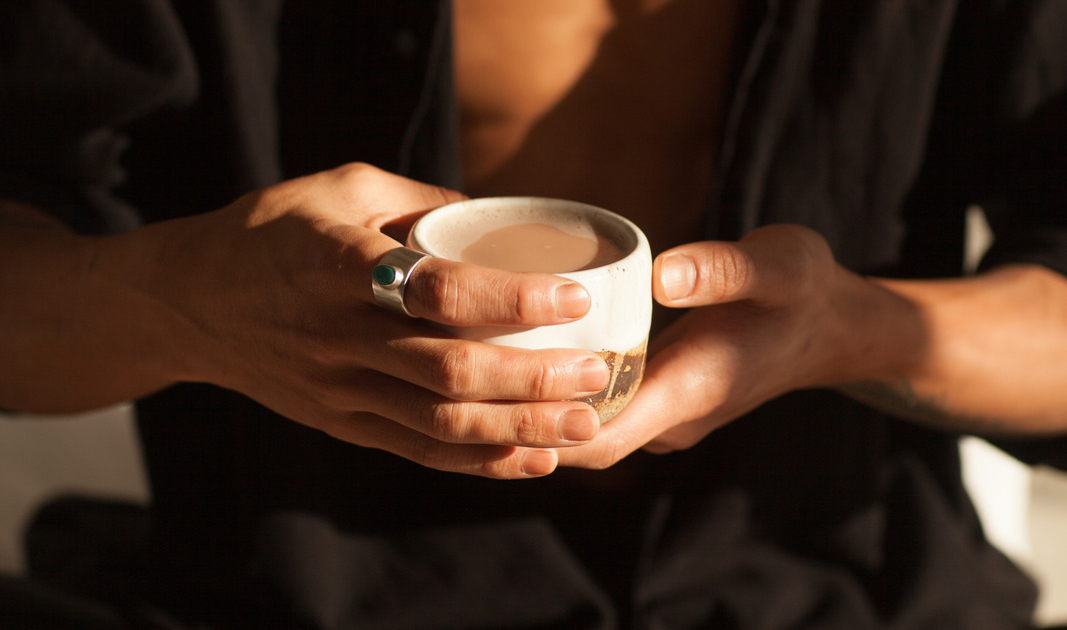 Close up image of a person holding a Cordyceps Mushroom Latte in both hands