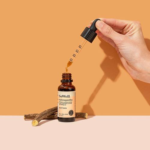 A person measuring their dose of Sowell Ashwagandha extract using the dropper tip