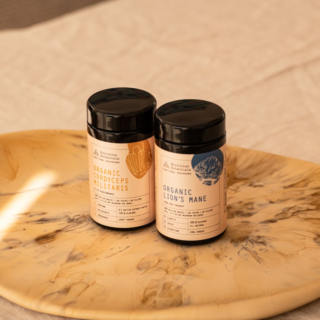 Jars of Organic Cordyceps Militaris and Organic Lion's Mane Jar Front sitting on a marble bench