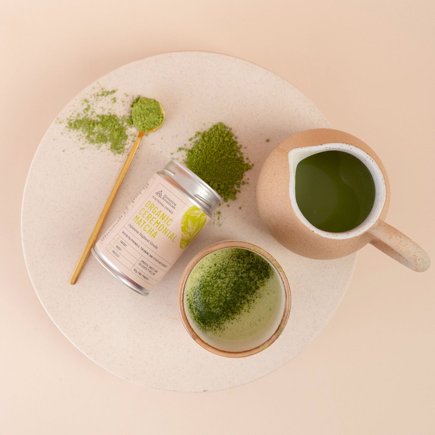 ceremonial matcha spilling out of its container with a drink of matcha sitting next to it