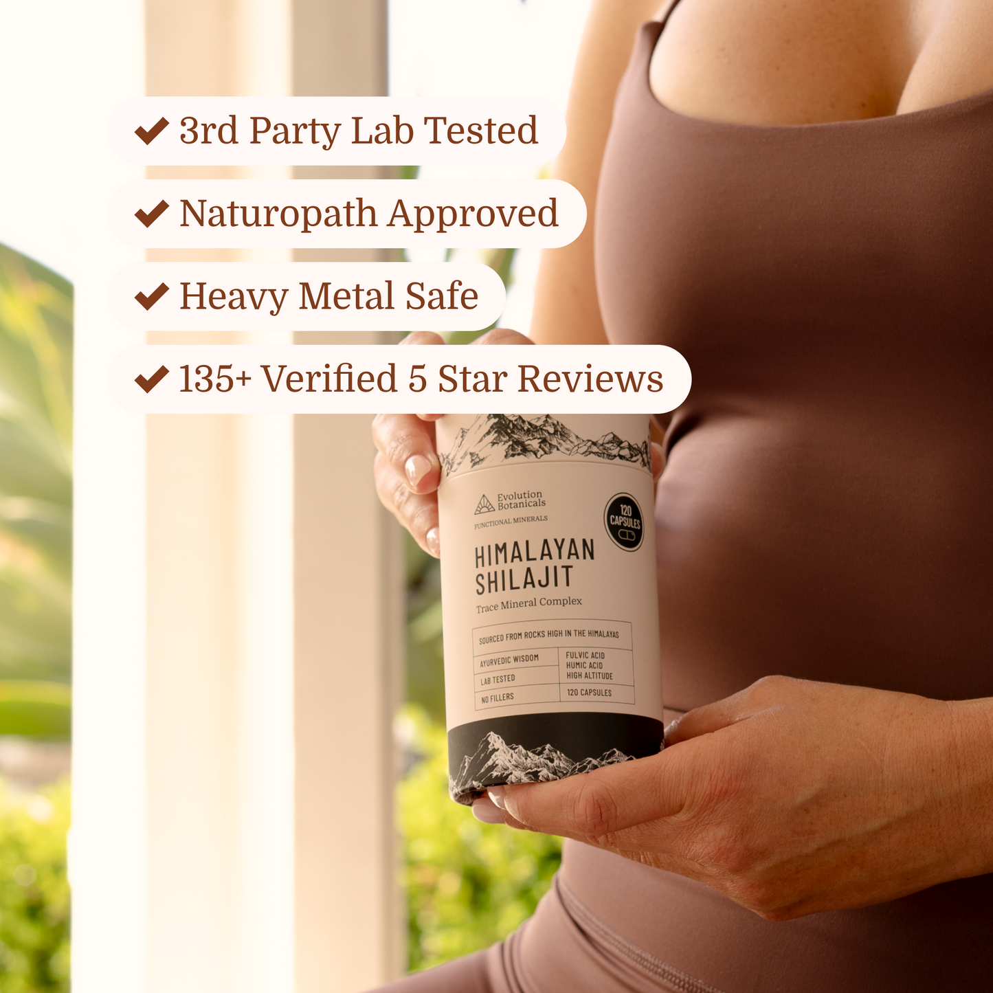lady holding himalayan shilajit capsules in active wear