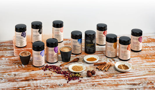 11 Evolution Botanicals arranged on a bench next to various bowls and mugs of liquids and powders. 
