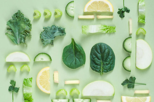 A top down image of various green vegetables and fruits that are beneficial for gut health. 