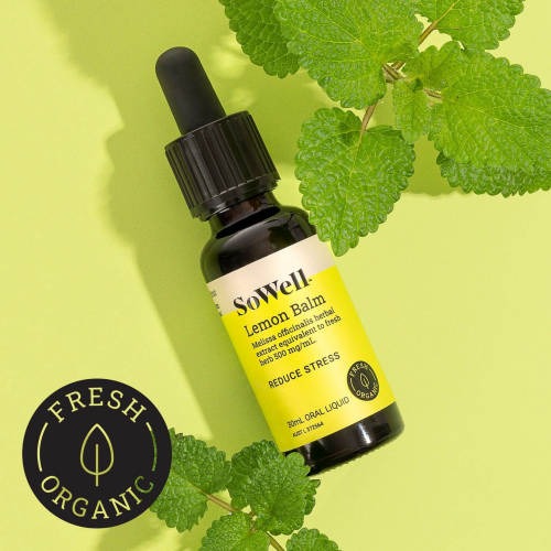 A 30ml dropper bottle of SoWell Lemon Balm Tincture liquid on a green background surrounded by lemon balm leaves