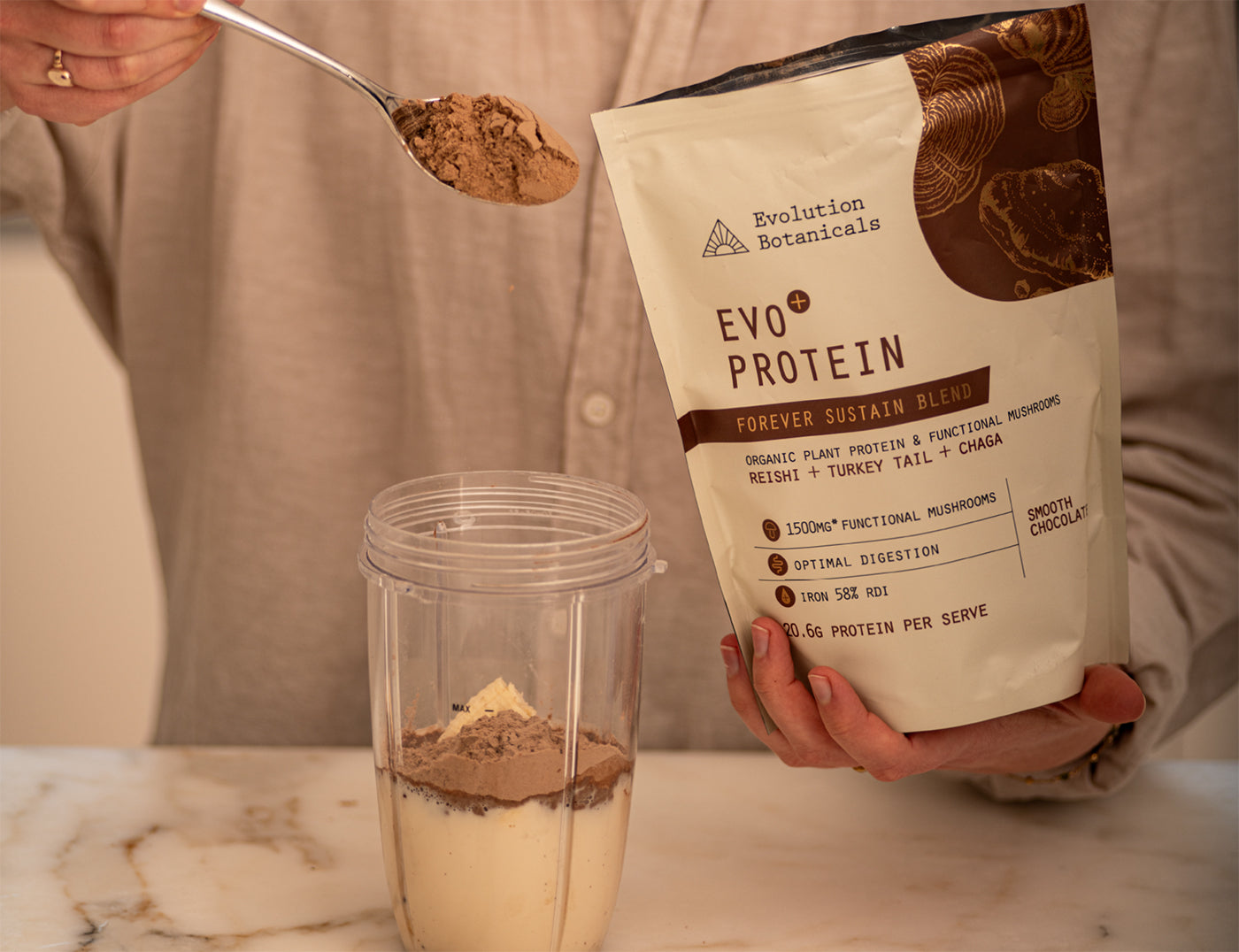 Lifestyle photo of a person spooning Evo Protein Smooth Chocolate into a protein shaker 